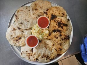 Assorted Salvadoran dishes including handmade pupusas, tamales, fried yuca, and plantains served fresh at Pupusería Patty’s