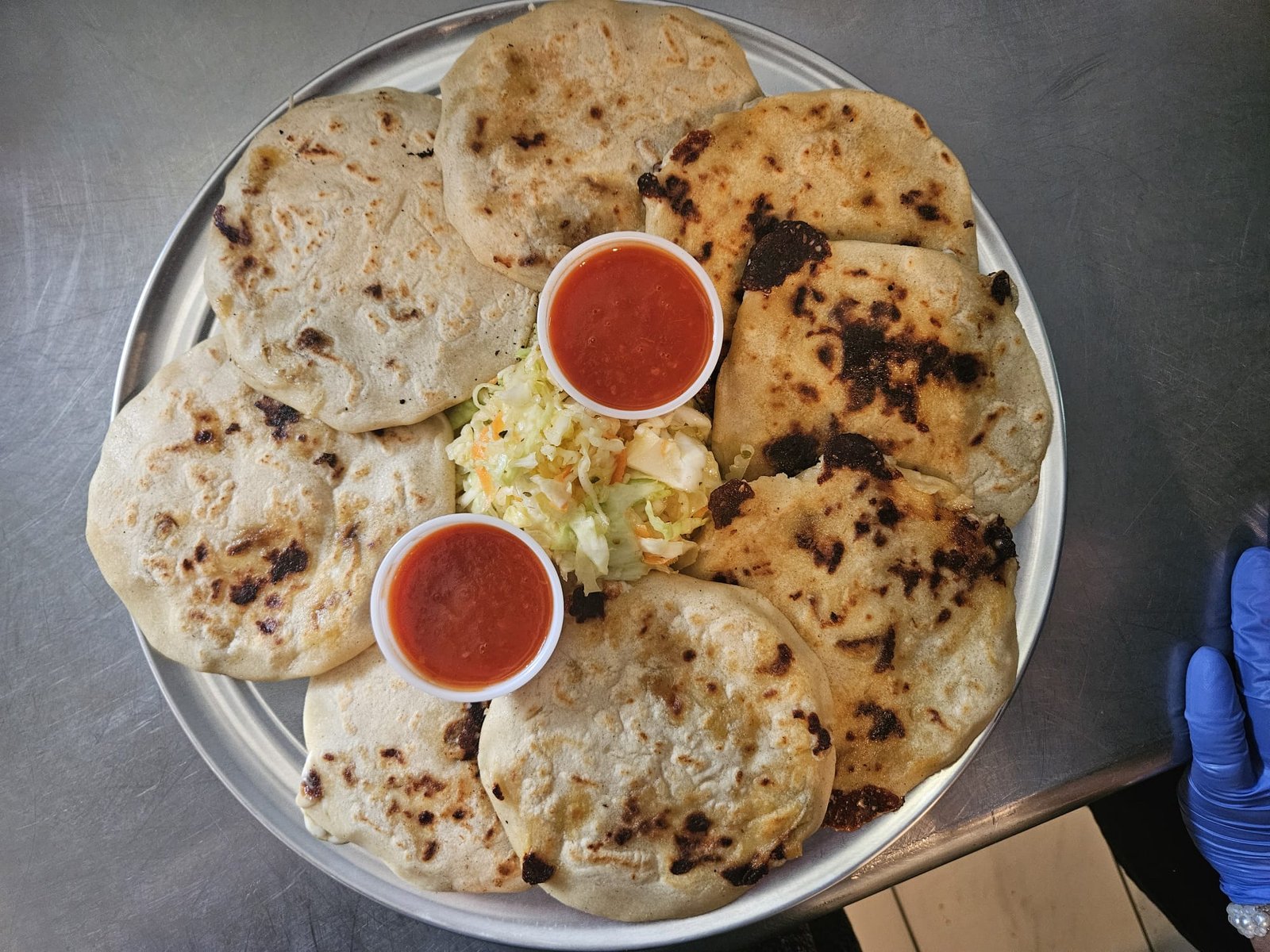 Assorted Salvadoran dishes including handmade pupusas, tamales, fried yuca, and plantains served fresh at Pupusería Patty’s
